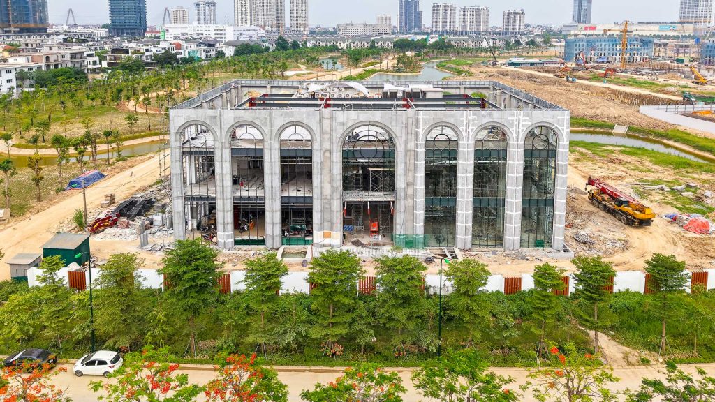 Cận cảnh tiến độ thi công thực tế Văn phòng bán hàng (Sales Gallery) dự án The Windsor Collection Ciputra. Công trình mang kiến trúc vòm độc đáo đang trong giai đoạn hoàn thiện mặt ngoài, lắp đặt hệ thống kính lớn và cơ điện.